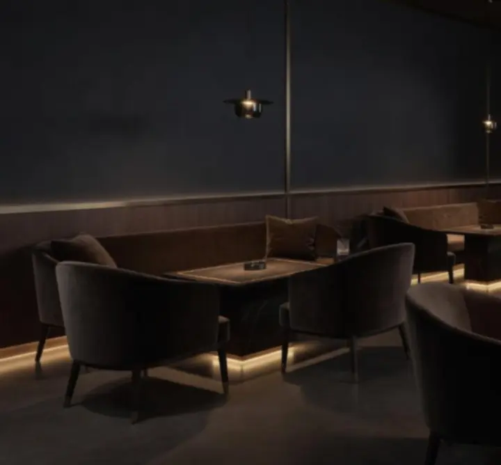 Wieczorna strefa lounge POLSKA AFTER DARK z eleganckimi stolikami i nastrojowym oświetleniem.